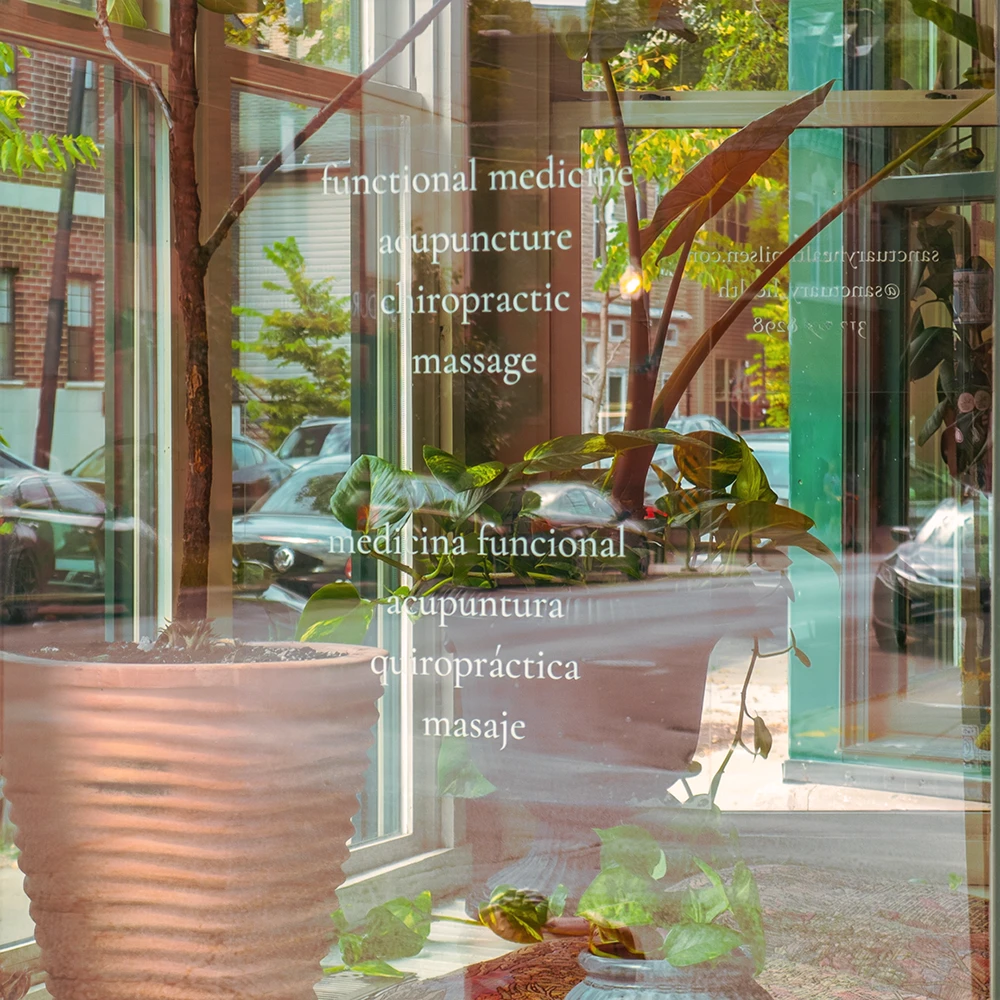 Sanctuary Health front window showing services such as functional medicine, acupuncture, chiropractic, and massage.
