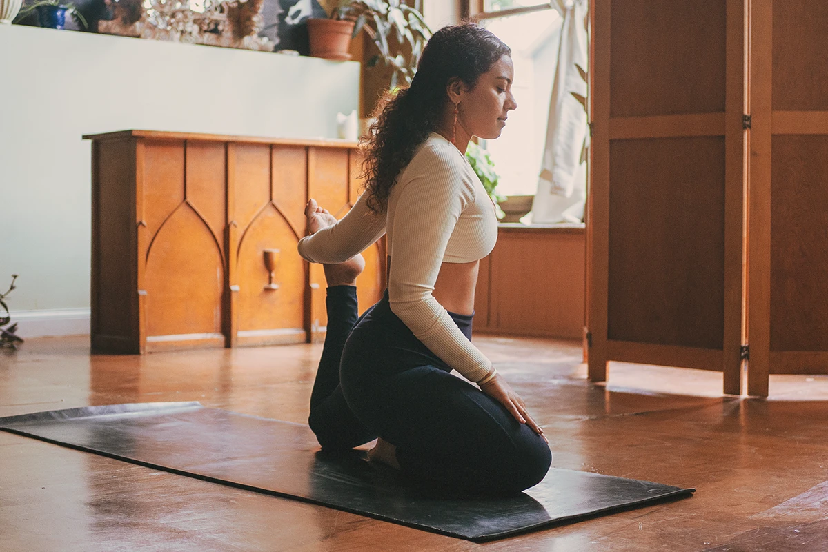 Person practicing yoga on a mat at Sanctuary Health Chicago, focusing on balance, breath, and mindful movement.