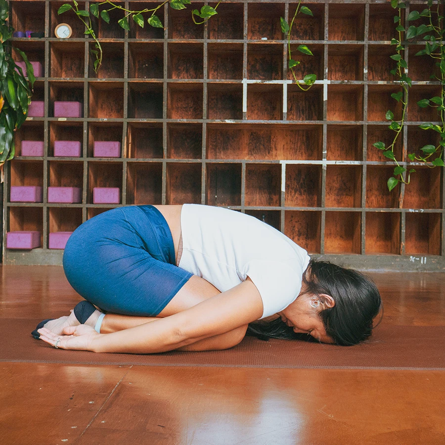 Yoga instructor practicing child’s pose in the Sanctuary Health studio.